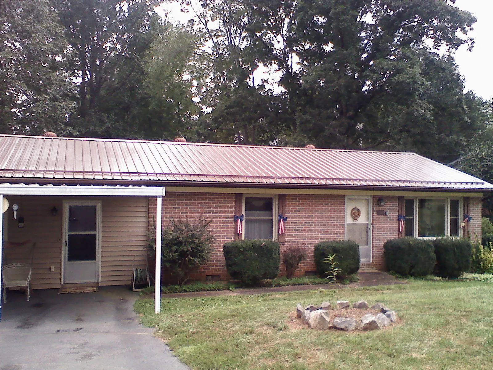 Bronze metal roof and carport on a brick ranch home — Roof Repair work by our crew in Fort Gaines