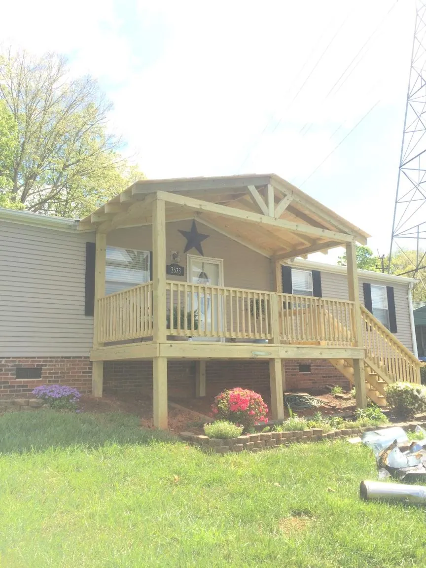 New gabled porch roof and deck railing added to a ranch home in Fort Gaines